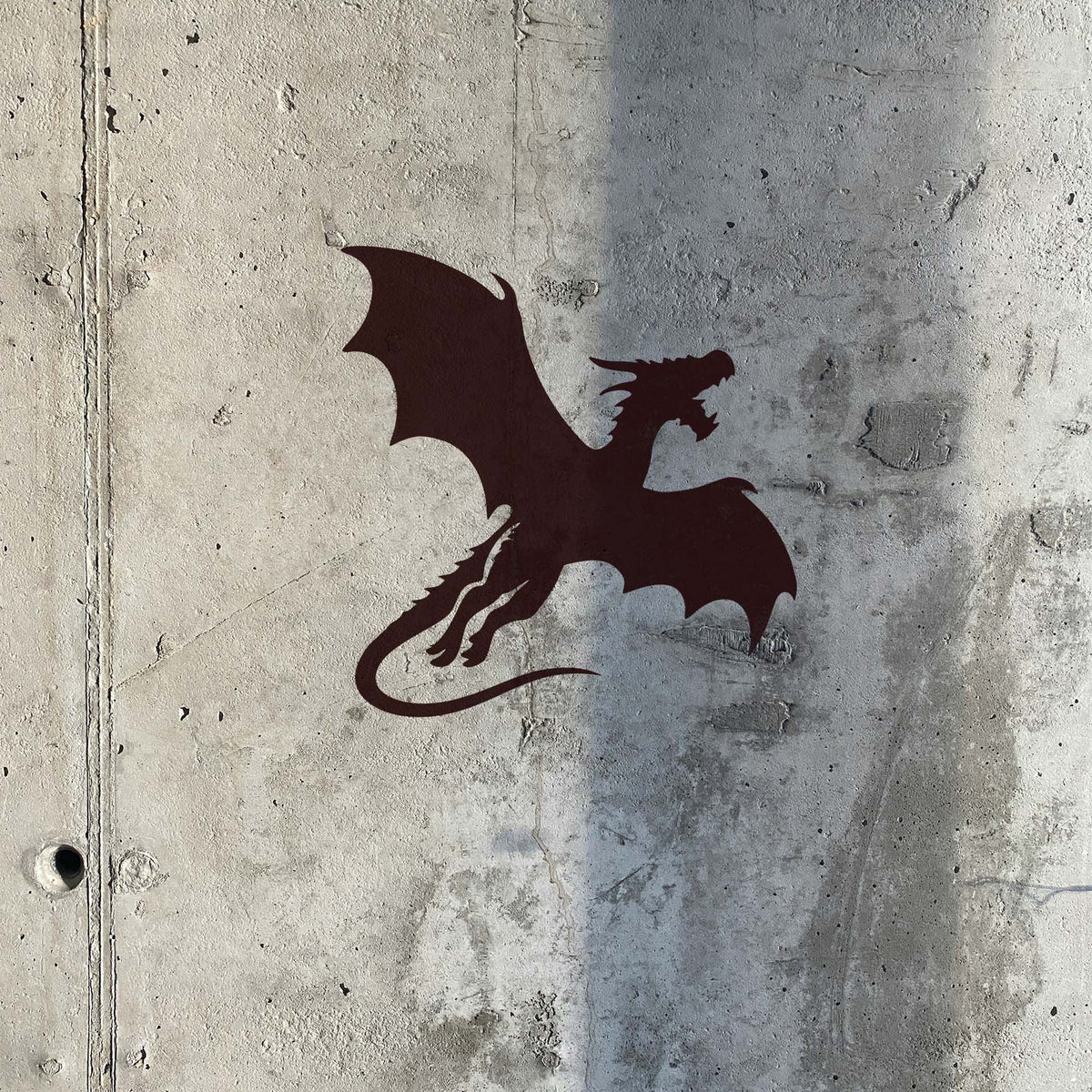 A Flying Dragon Silhouette Stencil stands out against a raw textured concrete wall