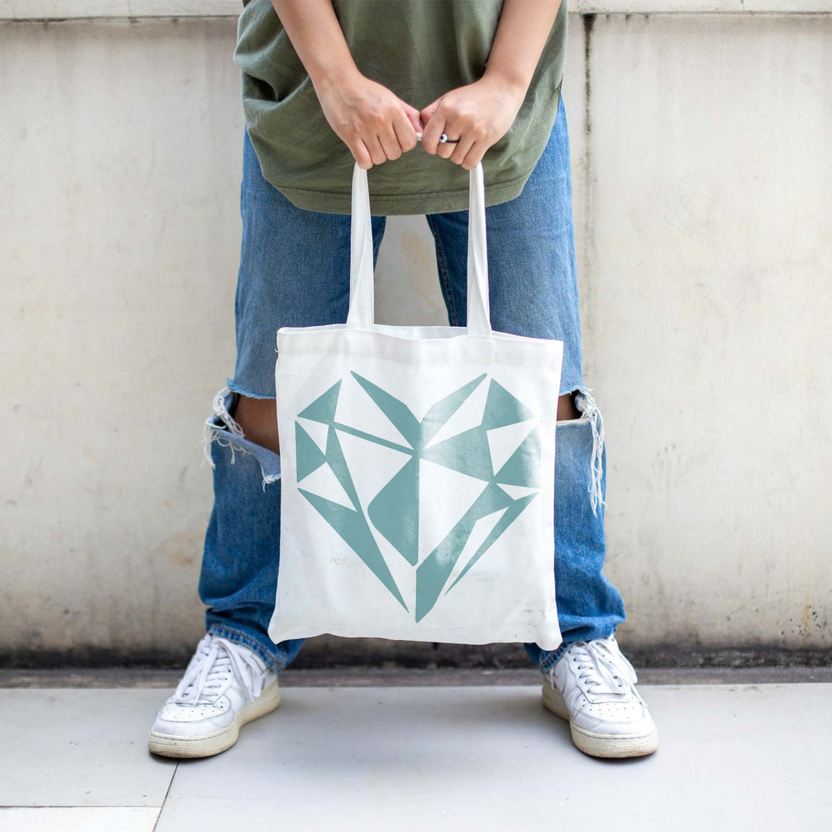 A white tote bag showcases the Geometric Heart Stencil in a soft blue angular design