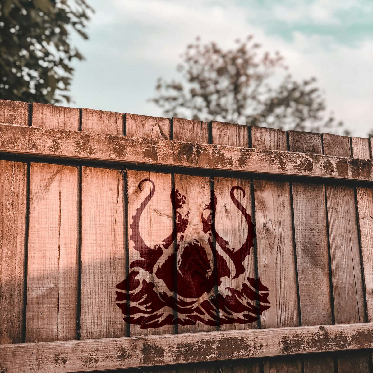 Ocean-inspired Giant Octopus Tentacles Stencil stretches across a rustic wood fence