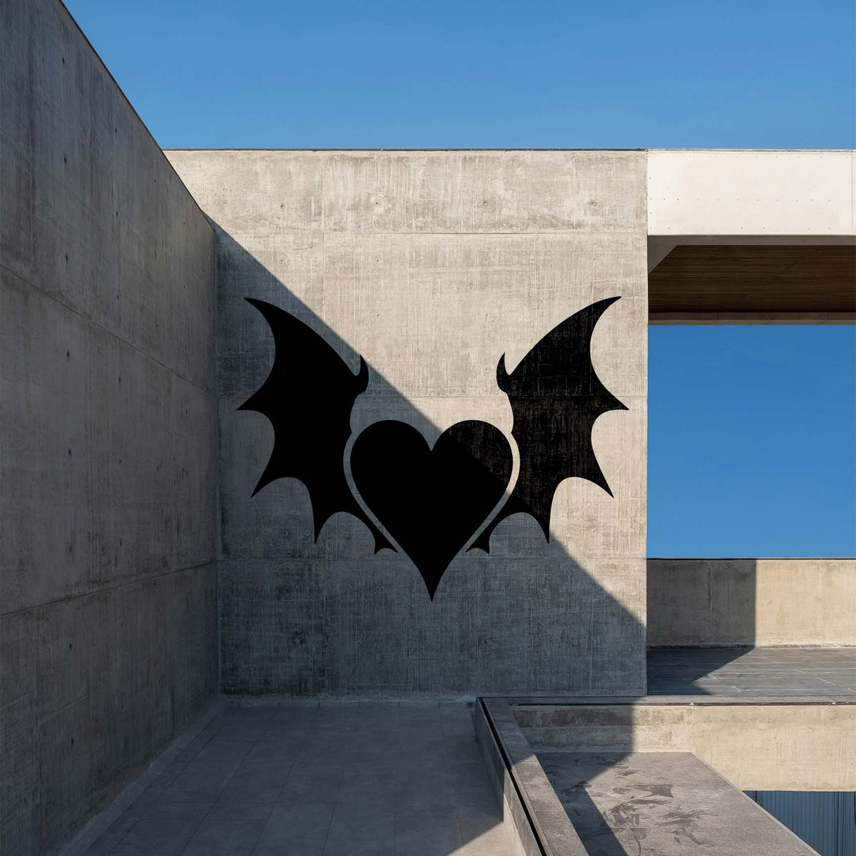Gothic Heart with Wings Stencil casts a bold black bat-winged heart across a concrete wall