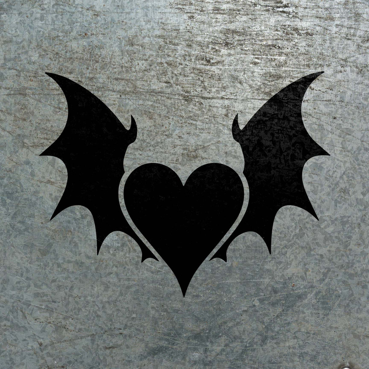 Against weathered metal, the Gothic Heart with Wings Stencil reveals a dark heart with sweeping bat wings
