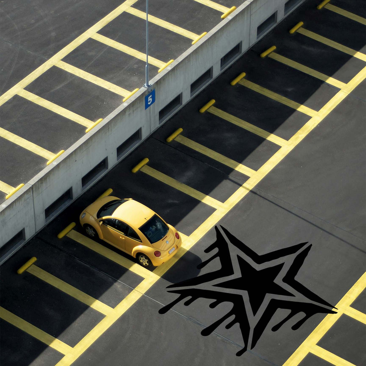 Graffiti Drip Star Stencil stands out in black across the asphalt of a marked parking lot