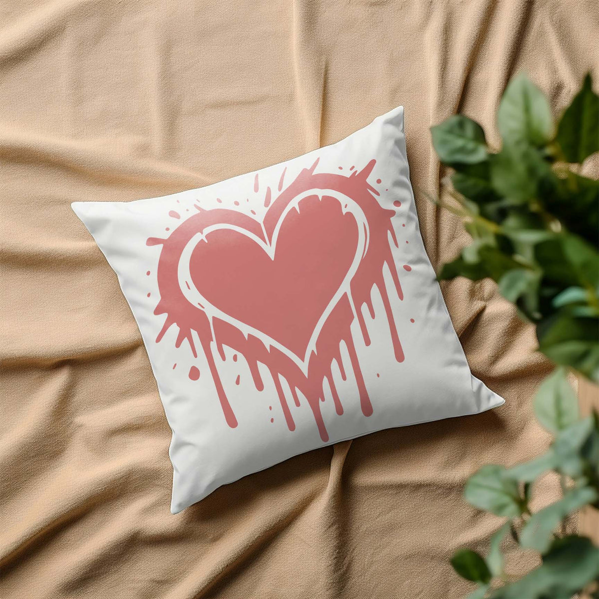 A soft pink Graffiti Heart Drip Stencil adds a playful splash of love to a white decorative pillow.