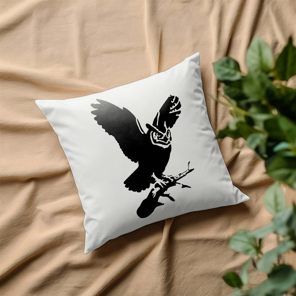 Great Horned Owl Stencil printed in black on a white pillow resting on beige fabric.