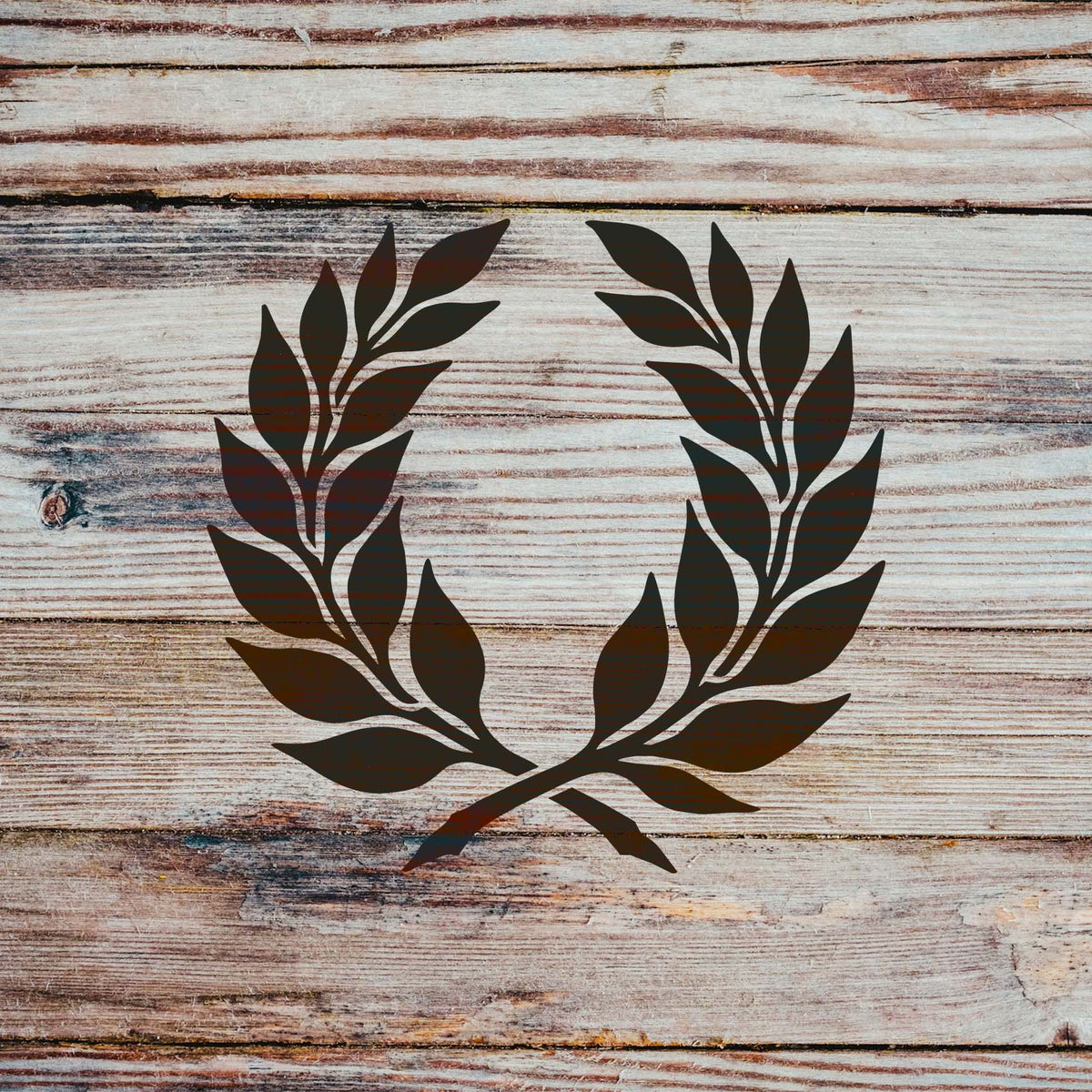 Elegant Laurel Wreath Stencil displayed in dark brown on weathered wood planks.
