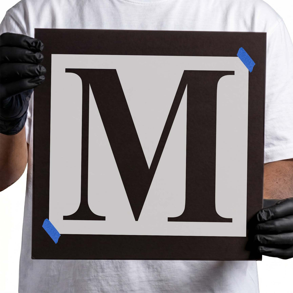 Uppercase letter M stencil featuring bold contrasting strokes and classic bracketed serifs