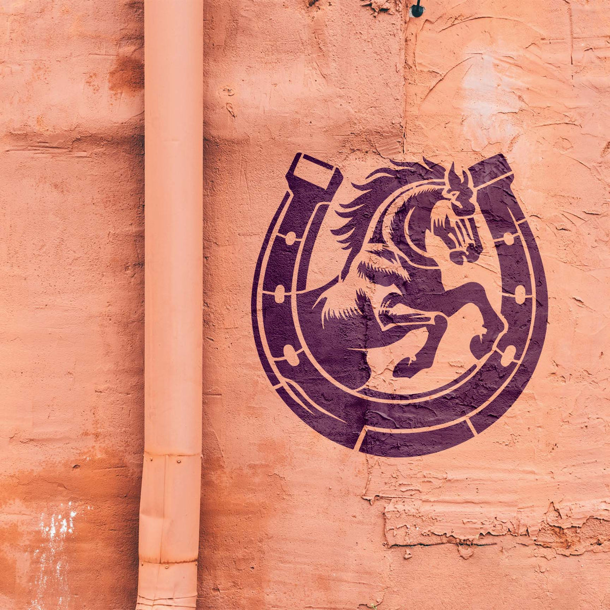 A textured salmon wall displays the Lucky Horseshoe Rearing Horse Stencil in deep purple