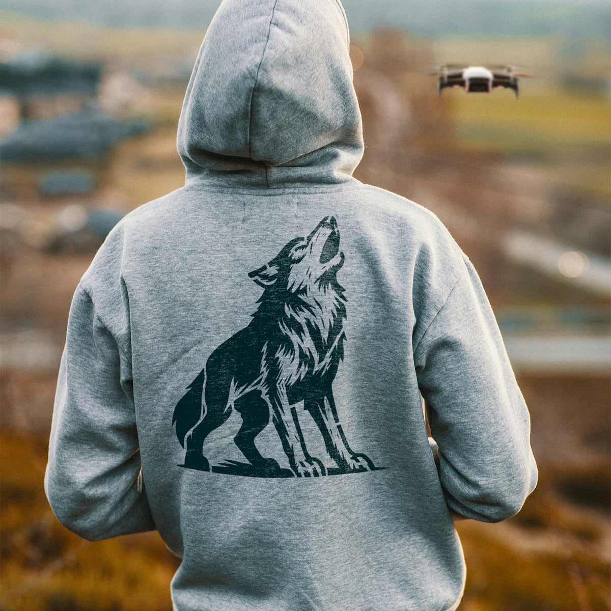 A Majestic Howling Wolf Stencil features a detailed black wolf raising its head on the back of a gray hoodie.