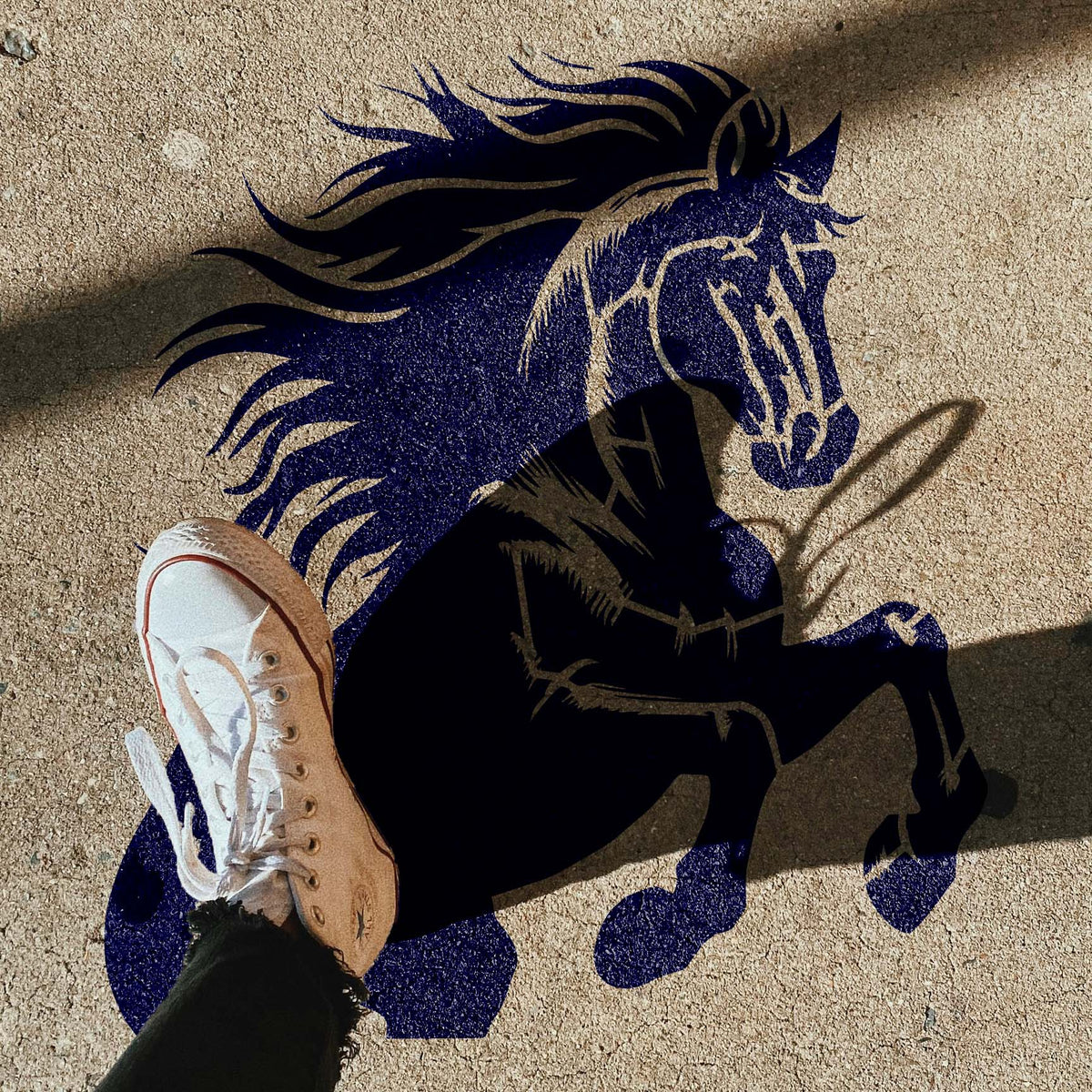 Beneath a sneaker, the Majestic Rearing Stallion Stencil shows a bold horse across a concrete sidewalk.