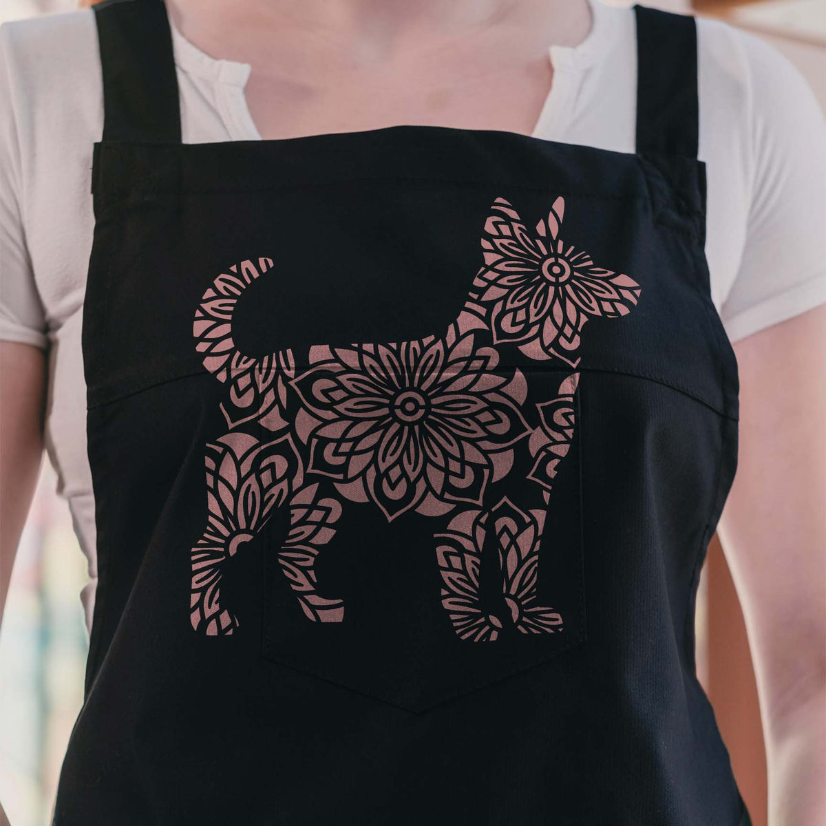 Rose gold Mandala Floral Dog Silhouette Stencil decorates a black apron with intricate blooms
