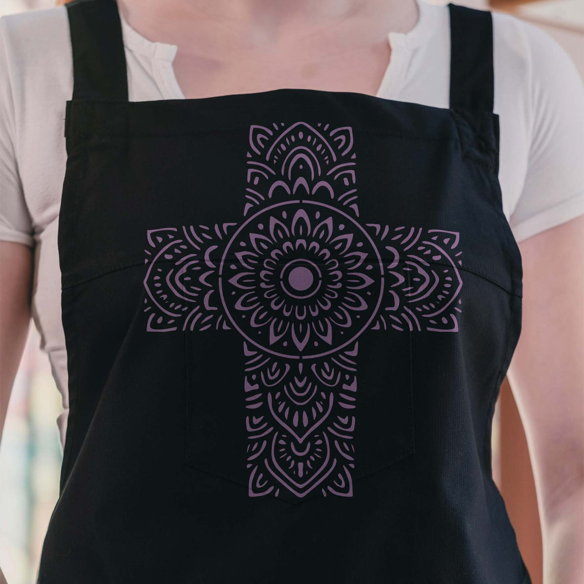 Purple Mandala Floral Cross Stencil adds intricate floral detail to a black apron