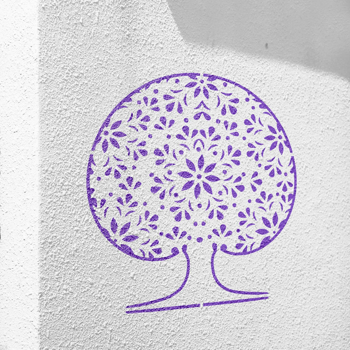 Mandala Tree of Life stencil painted purple on a textured white wall