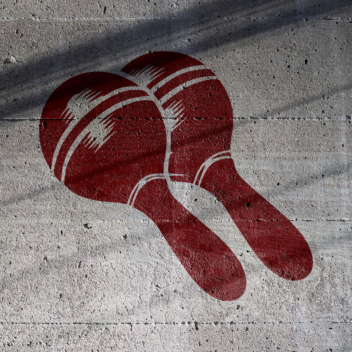 Deep red Maracas Stencil brings a paired maraca design to textured concrete