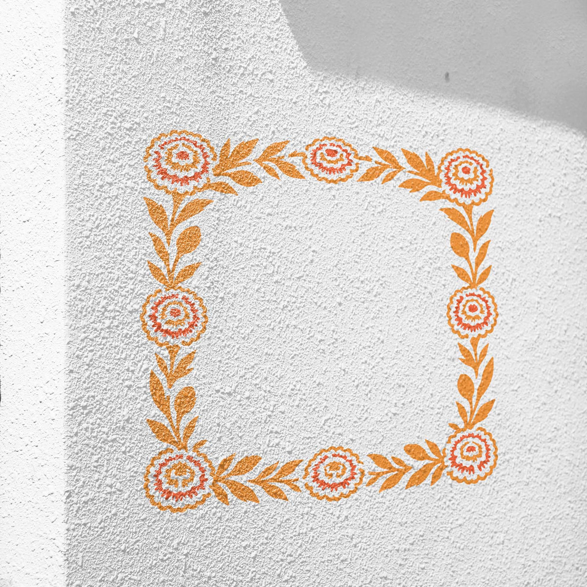 Floral Marigold Border stencil painted orange across a textured white wall