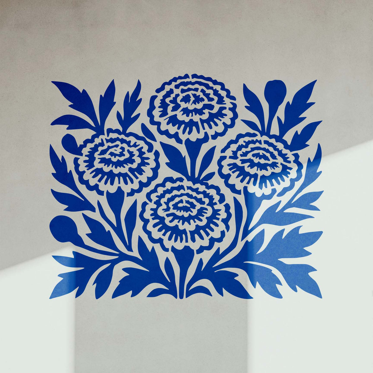 Marigold Flower Stencil shown in bold blue on a white interior wall corner.