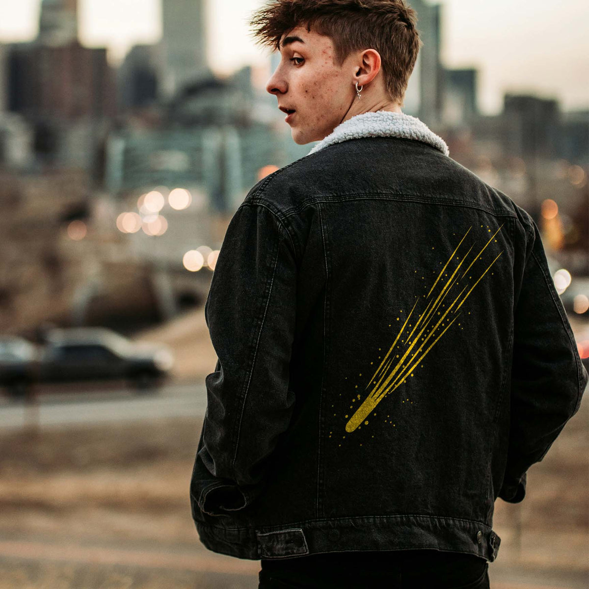 A shooting star glows in gold on a black denim jacket, showcasing the Meteor Streak Sky Stencil.