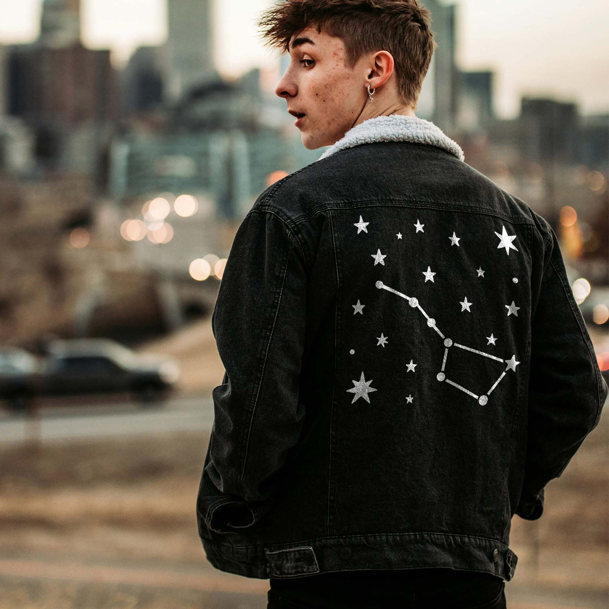 A black denim jacket displays the Northern Star Constellation Stencil in a crisp white celestial design