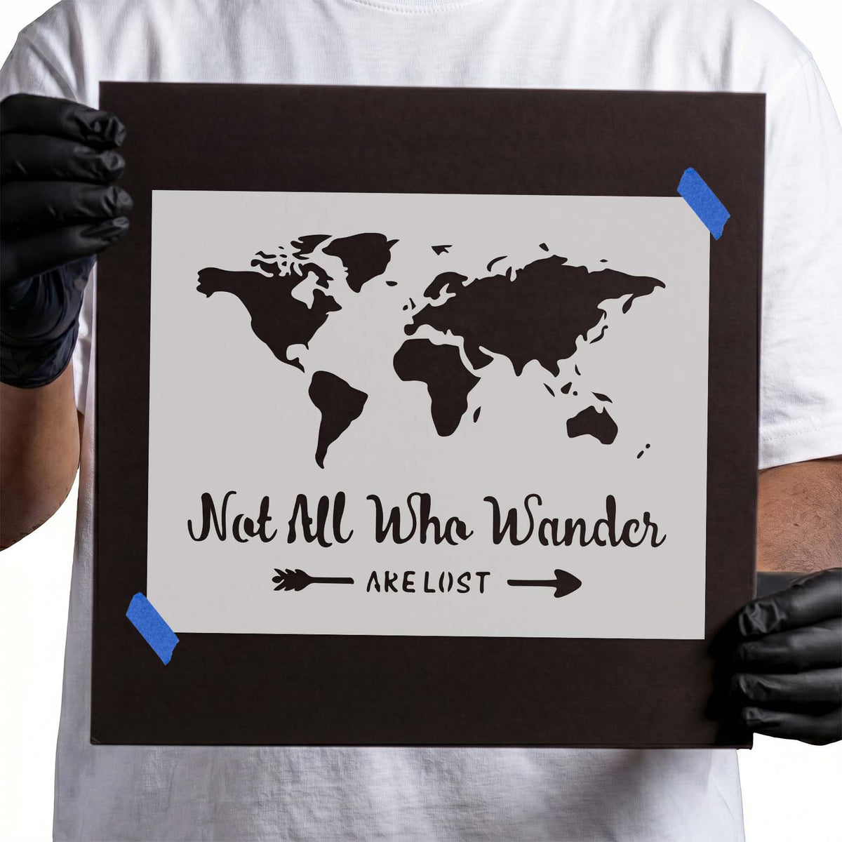 World map stencil with Not All Who Wander Are Lost lettering and arrows