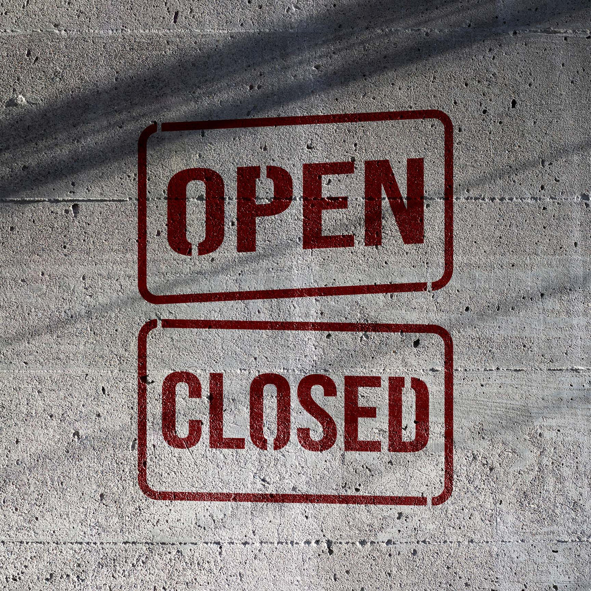 Open & Closed Sign Stencil displays bold business status lettering on concrete