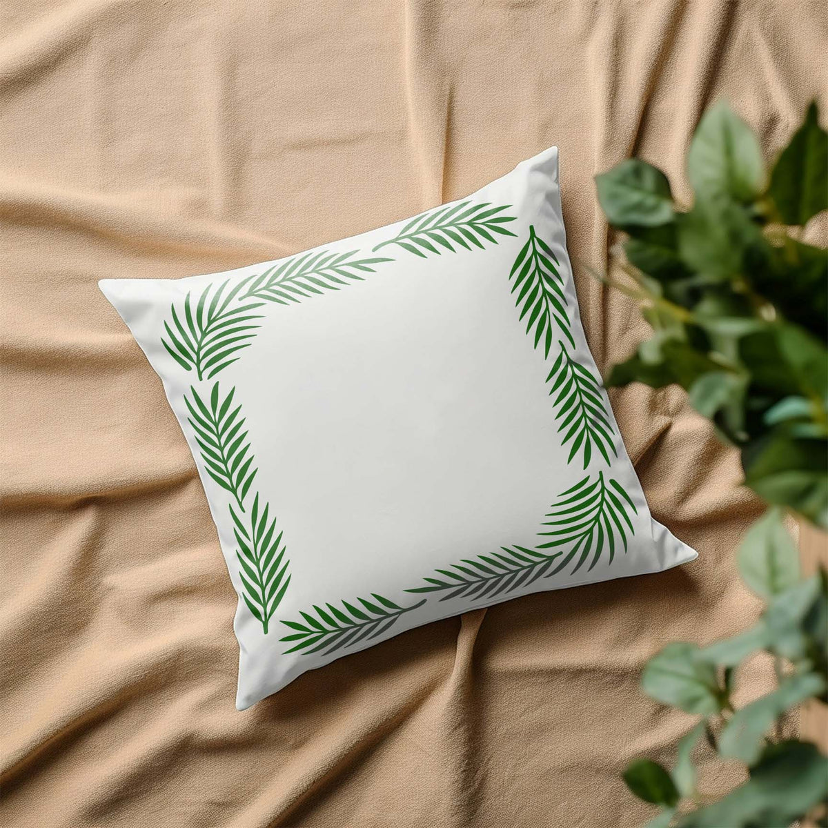 Green Palm Frond Border Stencil curves around the edges of a crisp white decorative pillow