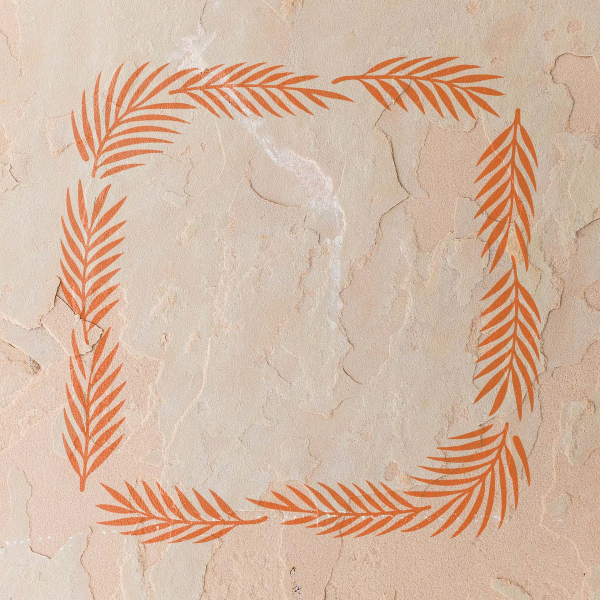 Orange Palm Frond Border Stencil forms a leafy frame across a textured stucco wall