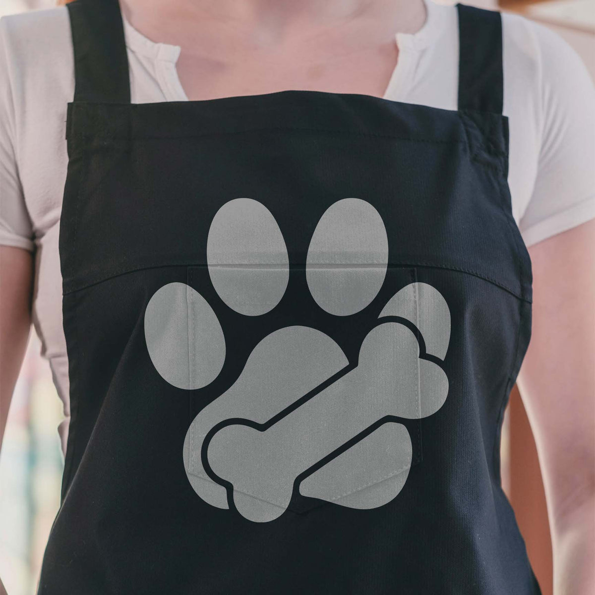 Paw Print with Bone Stencil adds a bold silver paw and bone motif to a black apron