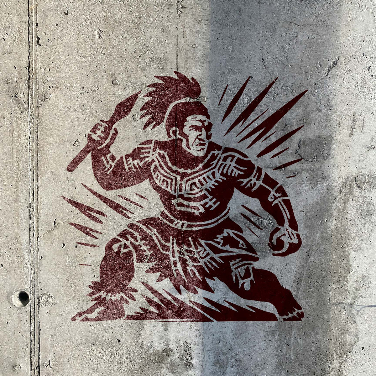 Polynesian Spear Warrior Stencil painted dark red on a textured concrete wall.