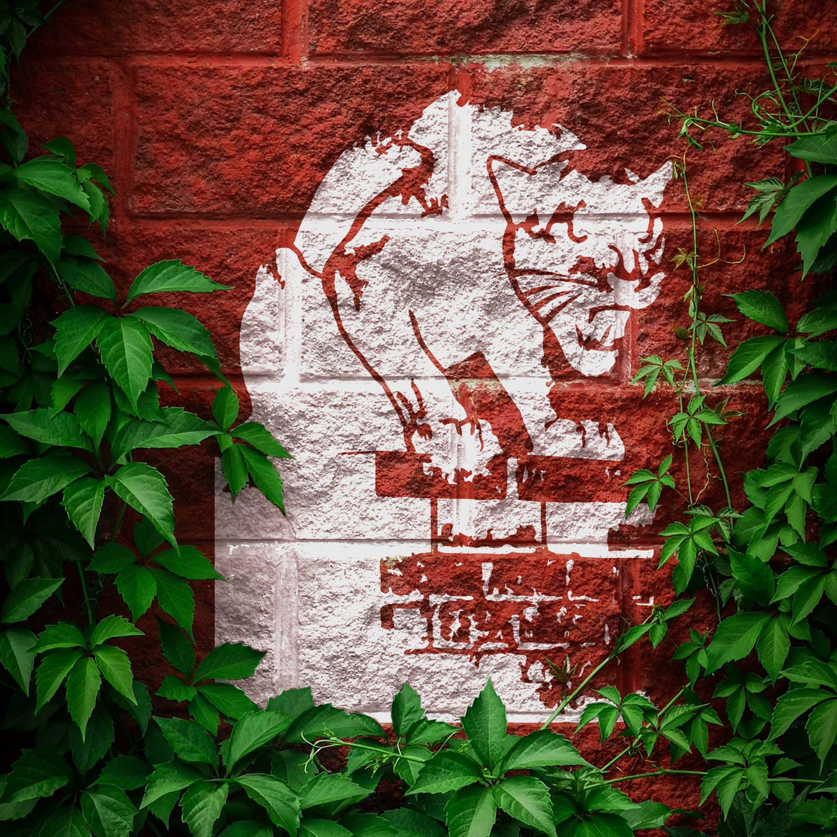 Weathered Prowling Panther Stencil stalks across a red brick wall framed by ivy