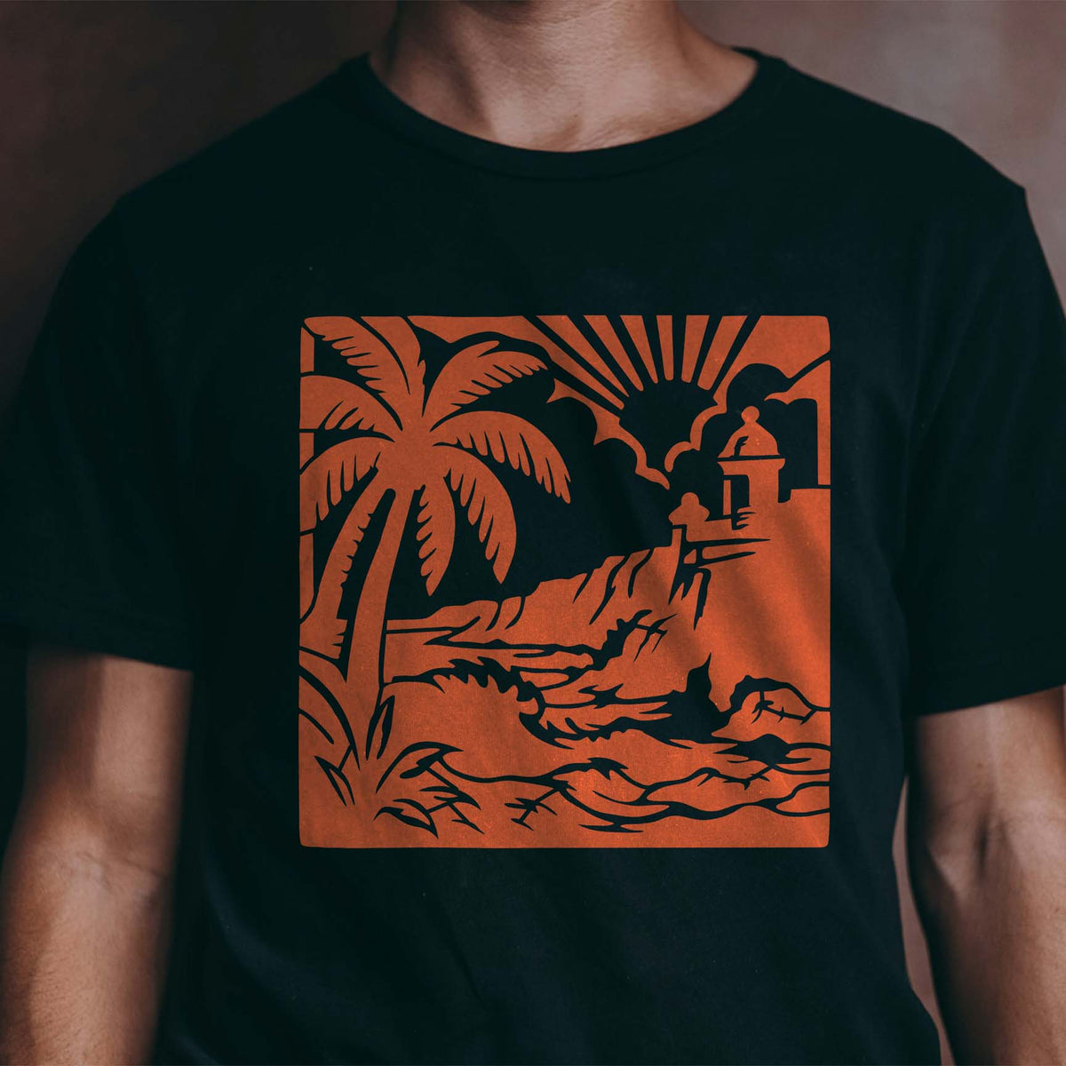 Orange Puerto Rico Coastal Fortress Stencil stands out with palm, waves and fort on a black shirt
