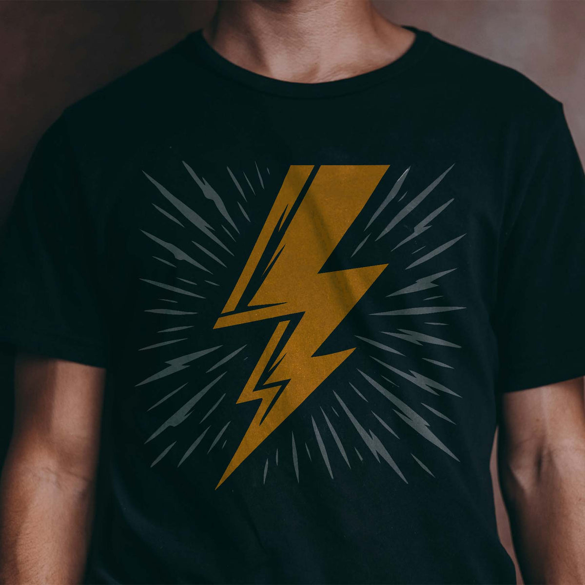 Golden Radiating Lightning Bolt Stencil flashes across a black T-shirt with sharp energy rays