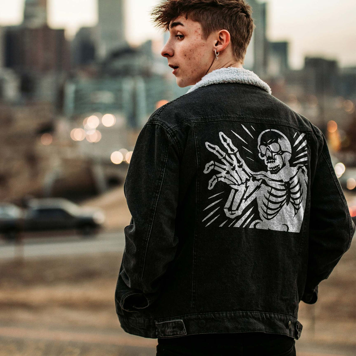 Reaching Skeleton Halloween Stencil stretches bony fingers across the back of a black denim jacket