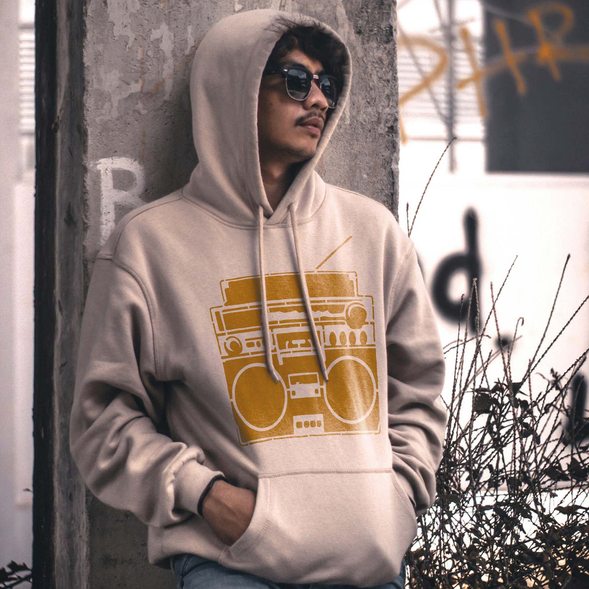 Golden Retro Boombox Stereo Stencil artwork features twin speakers and a cassette deck on a beige hoodie.