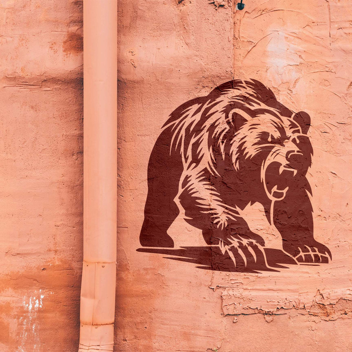 Roaring Grizzly Bear Stencil charges forward across a textured salmon-colored wall