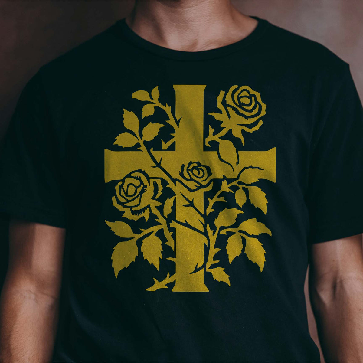 Golden Rose Vine Cross Stencil blooms across a black shirt with winding roses and leafy stems