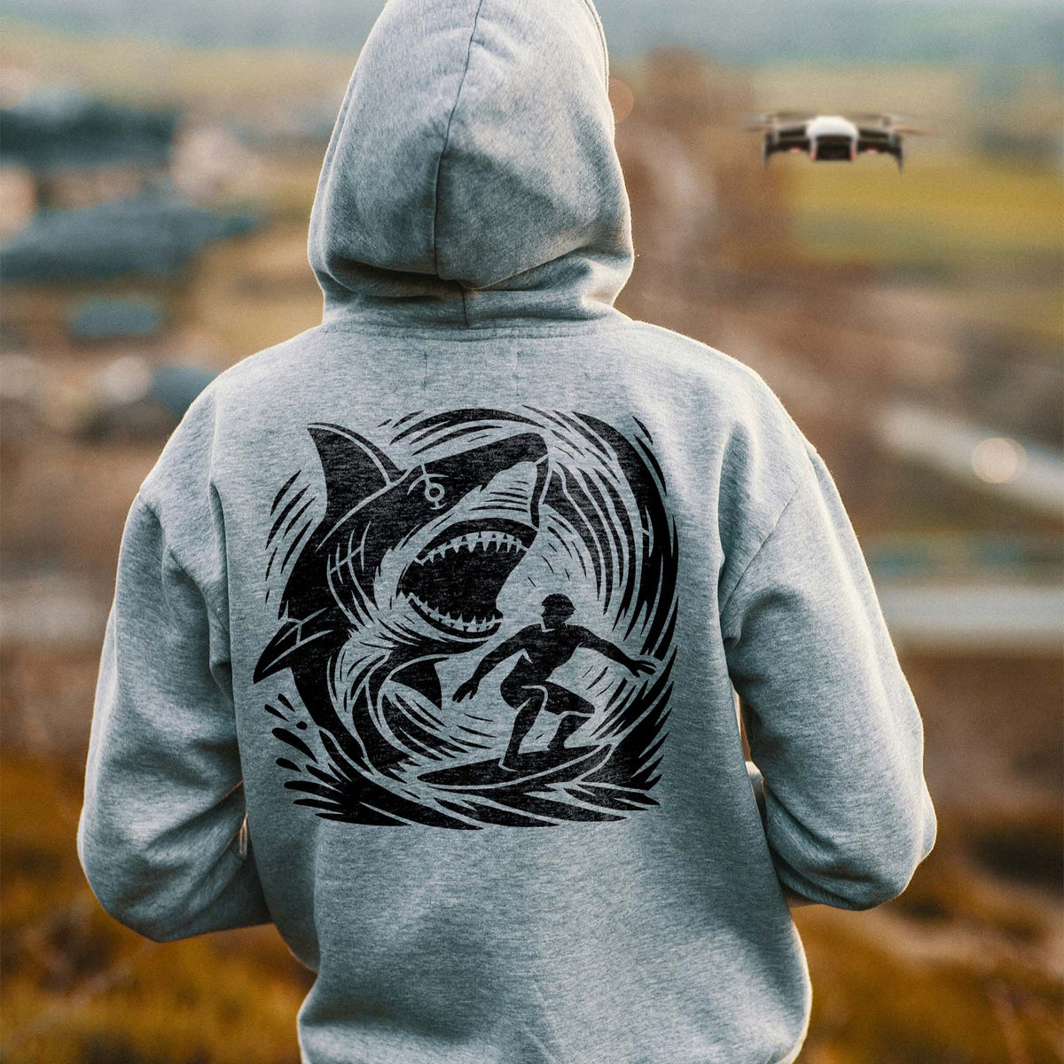 Shark Wave Chase Stencil brings a shark and surfer scene to the back of a gray hoodie