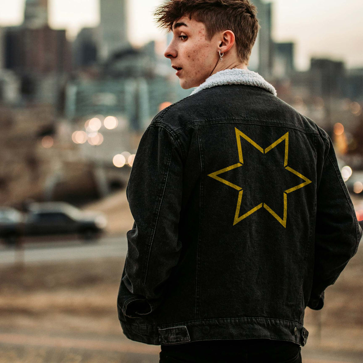 A golden Six Point Star Outline Stencil adds a sharp geometric accent to a black denim jacket