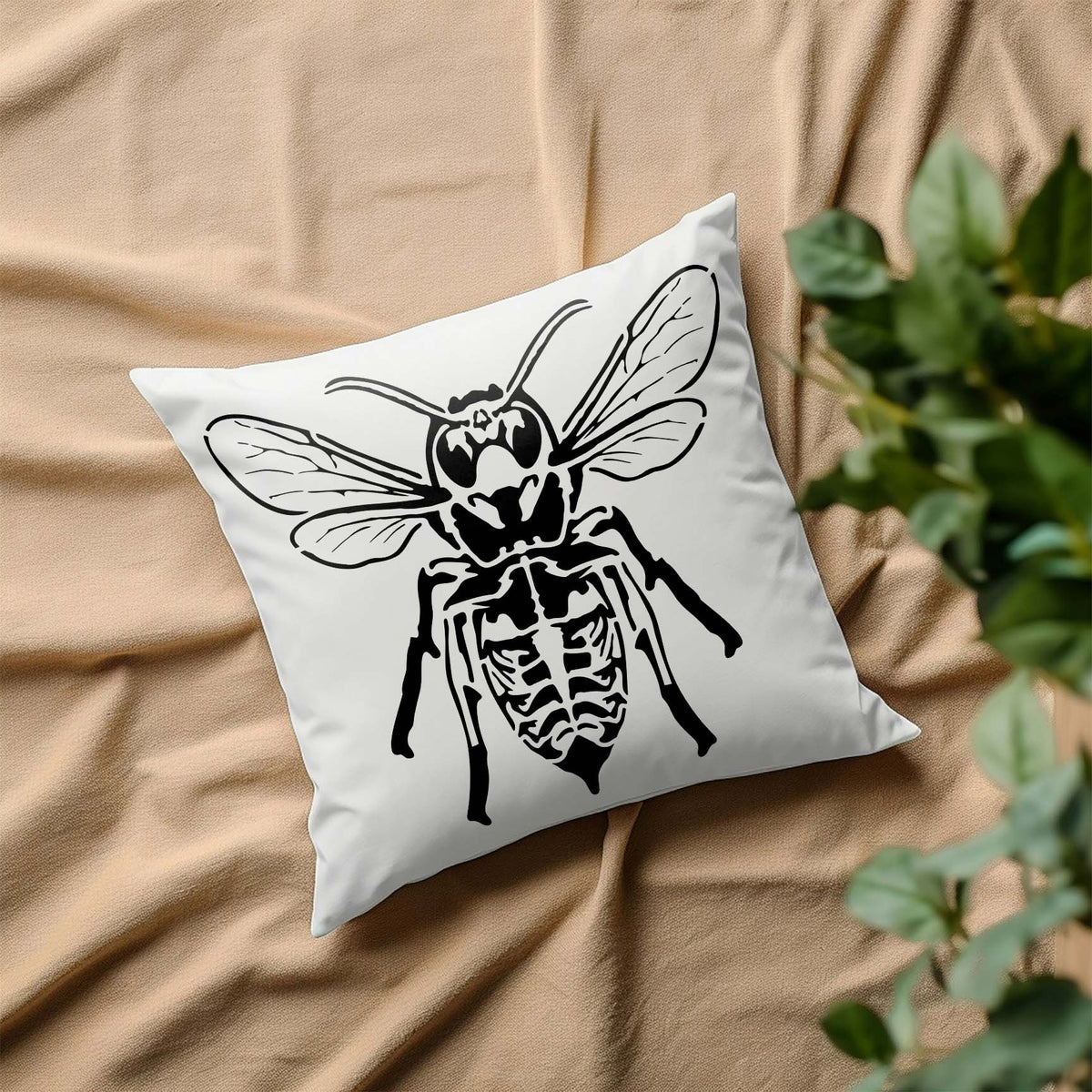 A skeletal bee spreads its detailed wings across a white pillow in the striking Skeleton Bee Stencil design.