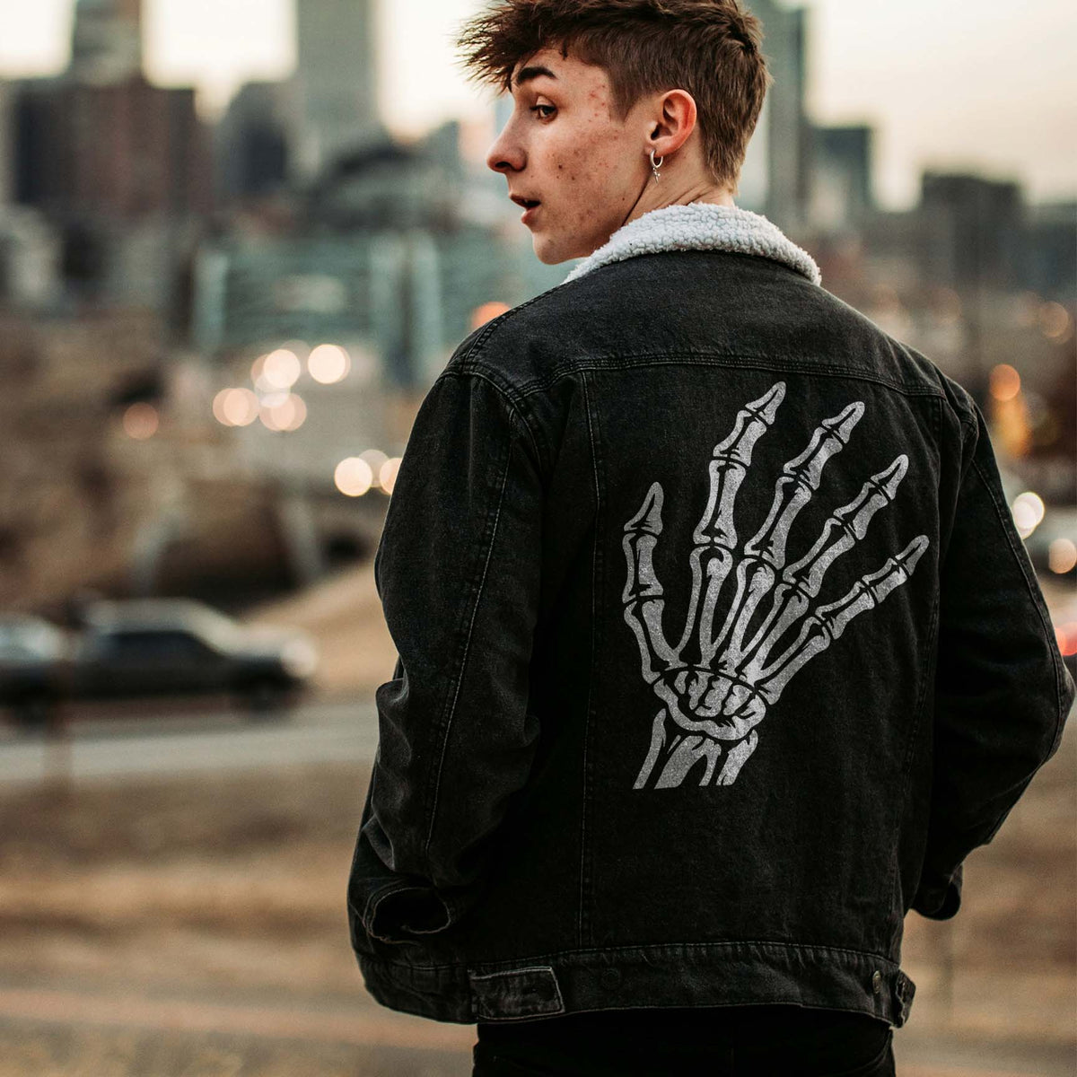 Skeleton Hand Bones Stencil stretches across a black denim jacket in a bold skeletal design