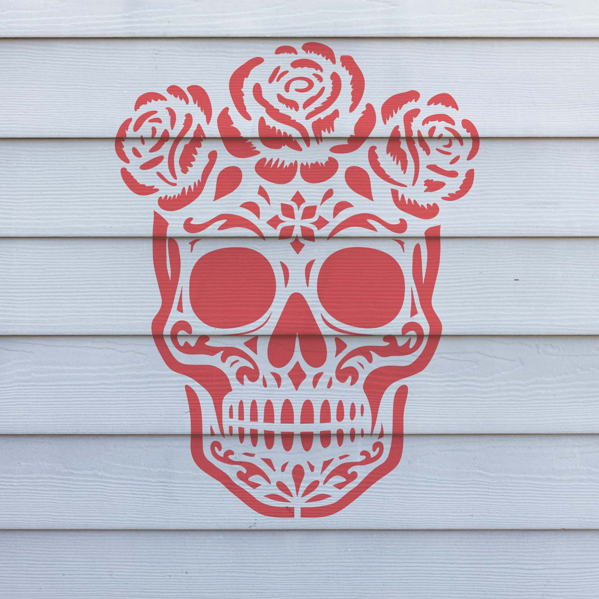 Pink Skull with Roses Stencil featuring three blooming roses painted on white horizontal wall siding.
