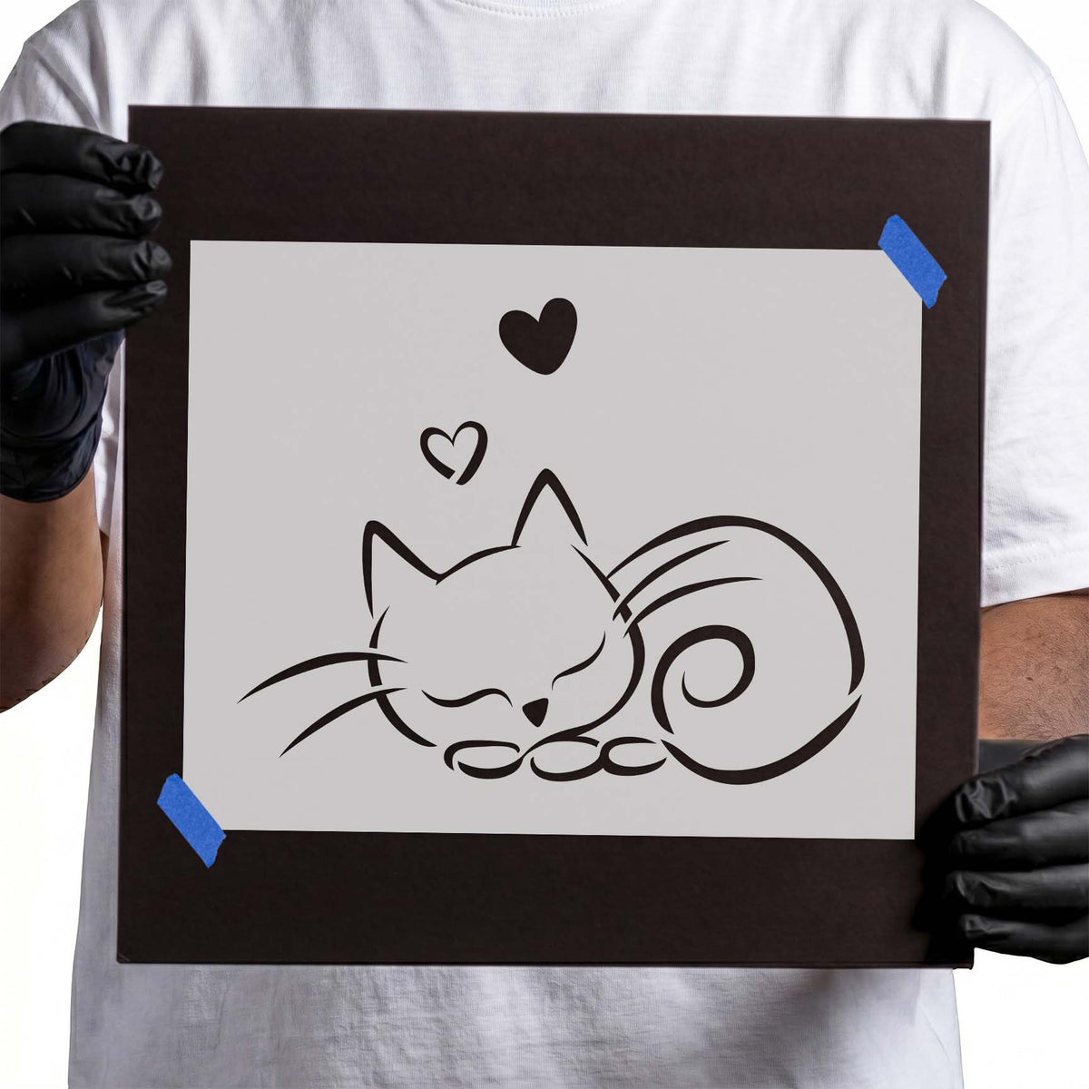 Sleeping cat stencil with closed eyes, curled spiral tail, whiskers, and two hearts