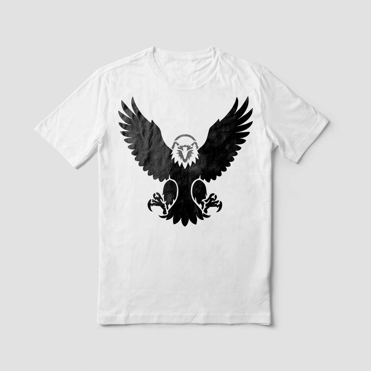 A white T-shirt showcases the Soaring Eagle Front View Stencil in black with raised wings and a piercing gaze.