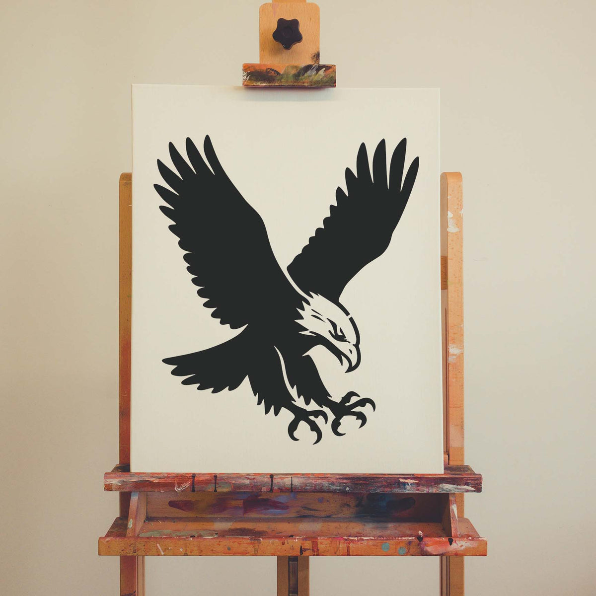 A striking Soaring Eagle Talon Stencil displays outstretched wings and sharp claws on an easel canvas.