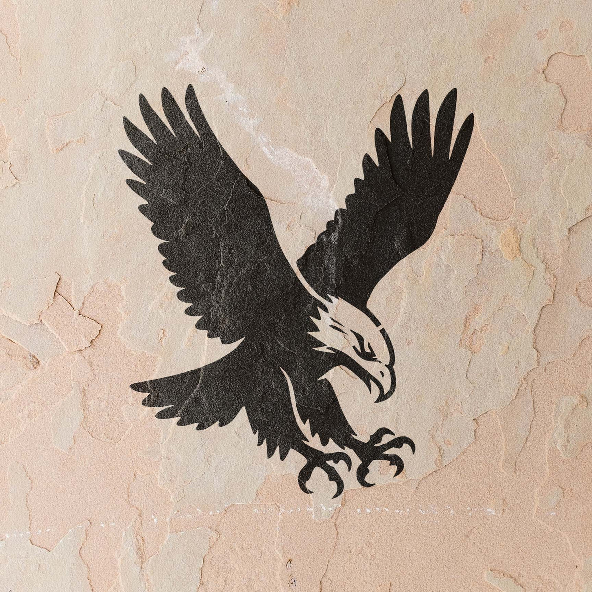 Against a textured beige wall, the Soaring Eagle Talon Stencil captures a diving eagle with claws extended.