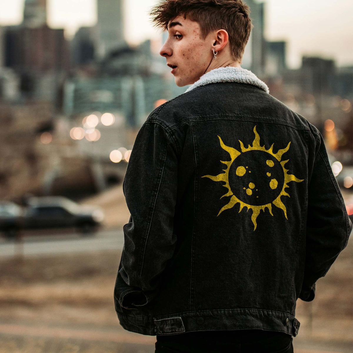 A molten gold sun from the Solar Flare Stencil commands the back of a black denim jacket