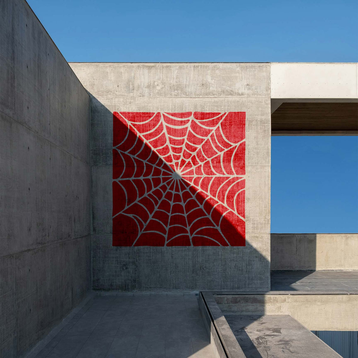Spider Web Radial Pattern Stencil spans a modern concrete wall in a striking red square design