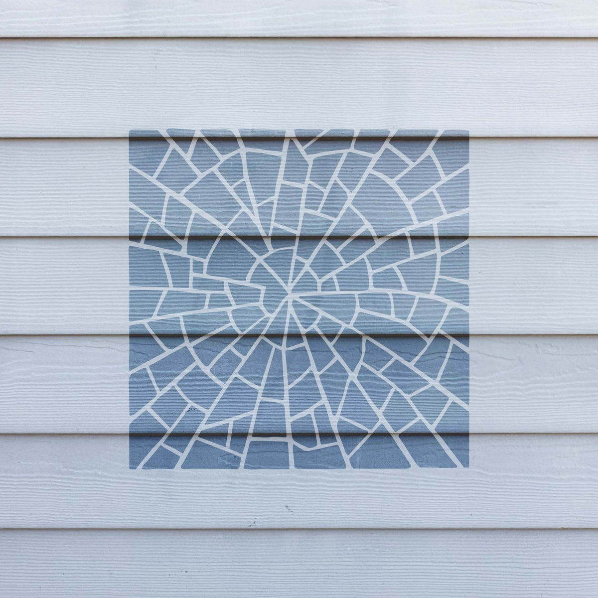 Spiral Stone Mosaic Pattern Stencil displays a soft blue mosaic spiral across white exterior siding
