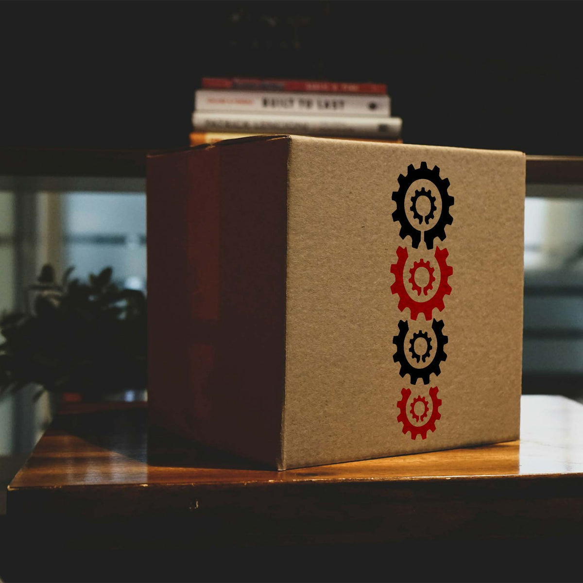 Stacked Gears stencil with alternating black and red cogwheels printed vertically on a cardboard box
