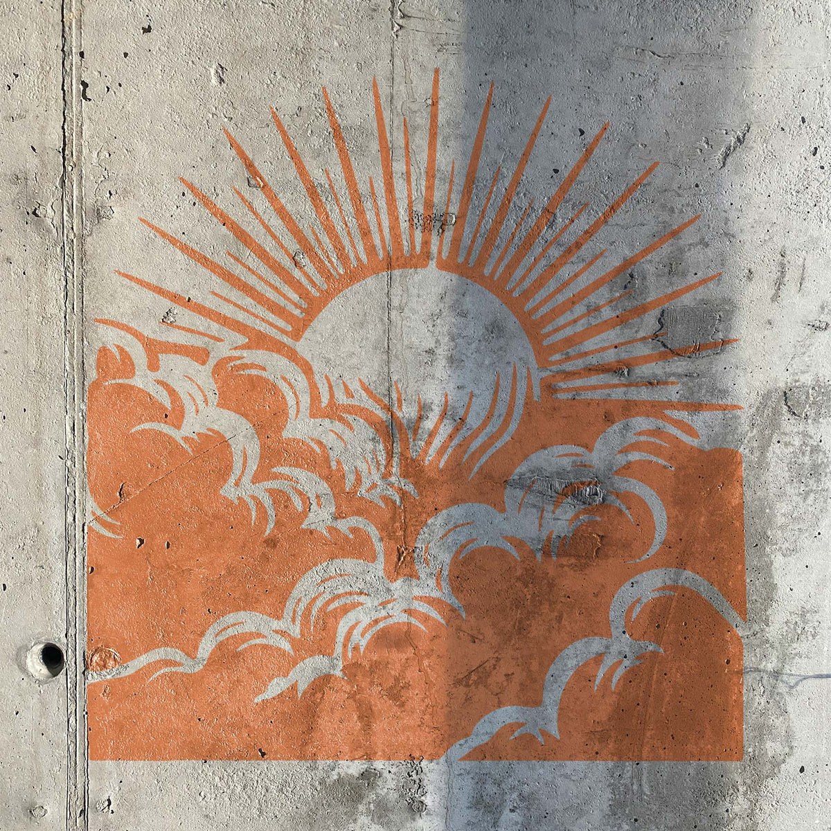 Sunrise Above Clouds Stencil painted in orange across a textured concrete wall