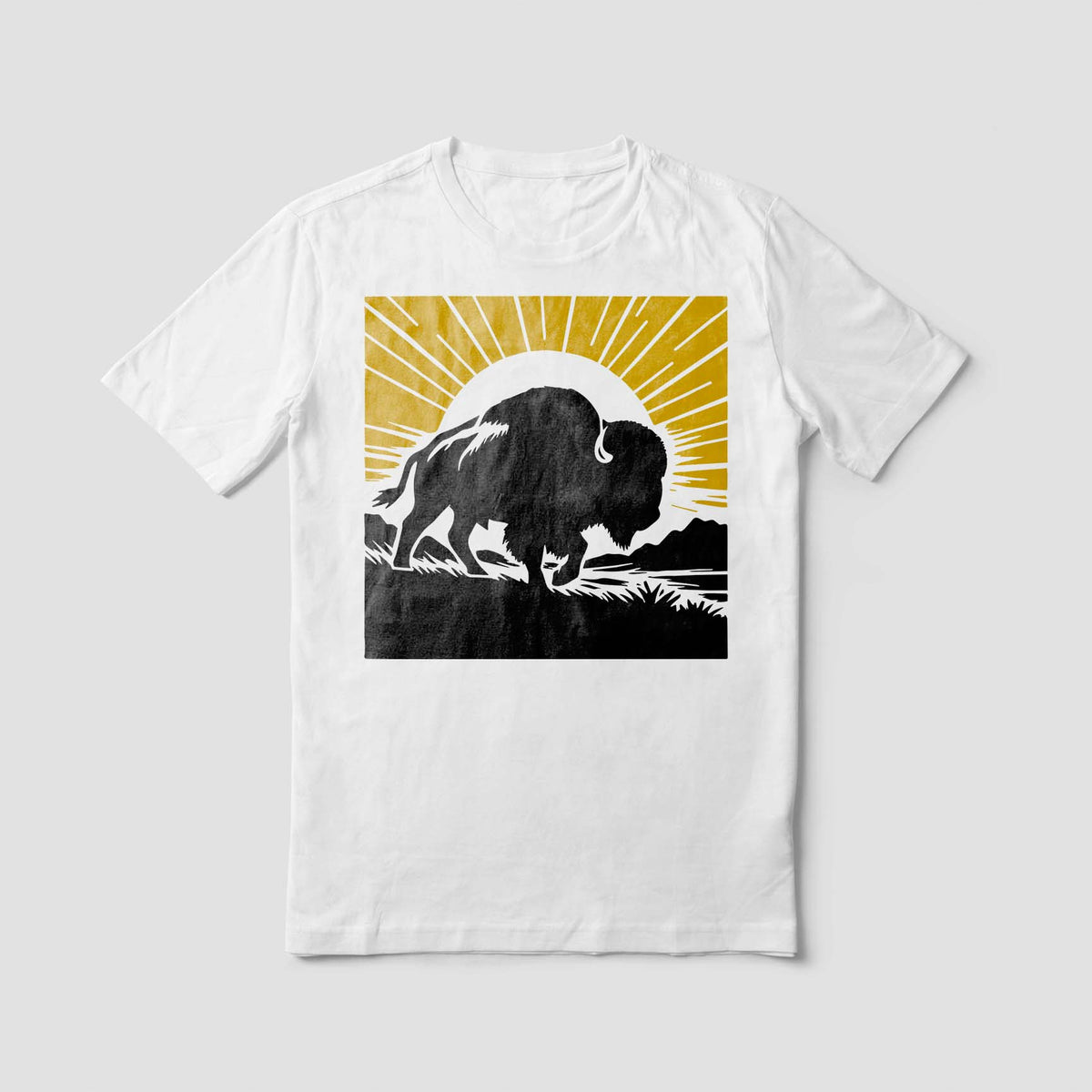 A white tee features Sunrise Buffalo Silhouette Stencil with a black buffalo beneath golden rays