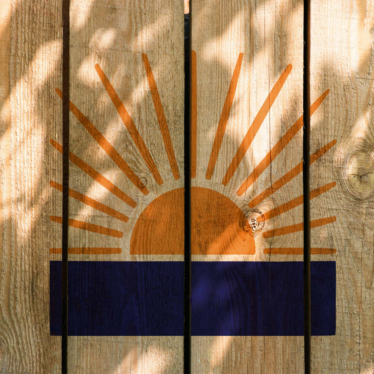 Across rustic wood, Radiant Sunrise Horizon Stencil pairs orange sun rays with a bold blue horizon